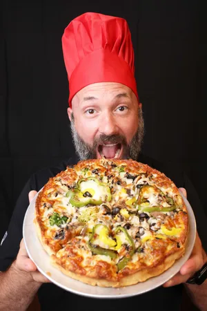 Justin Kelly, General Manager at Cape Cod in Brockton, holds a vegetarian pizza on Tuesday, July 30, 2024.